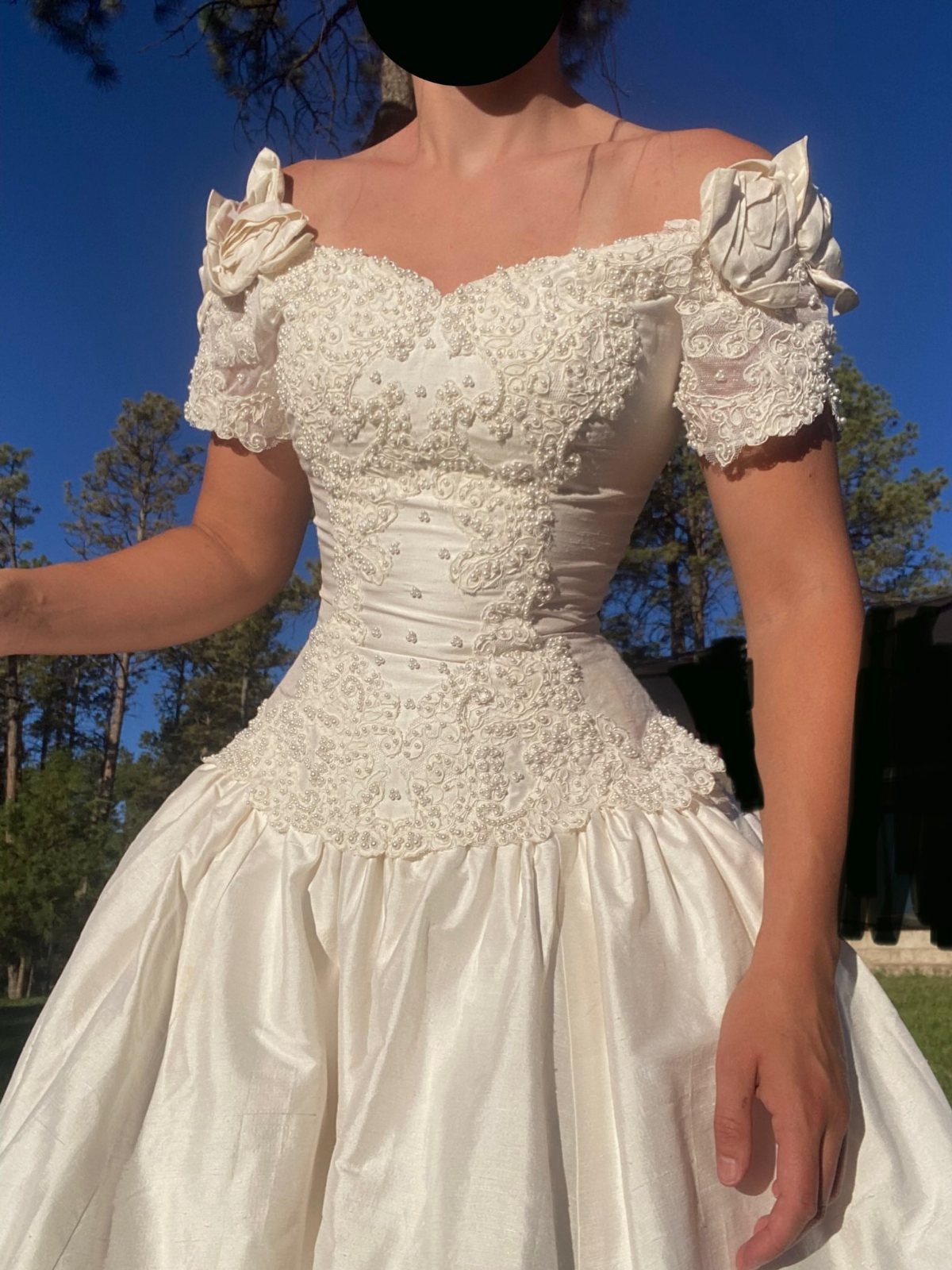 White vintage wedding gown with a structured corset bodice and full satin skirt.