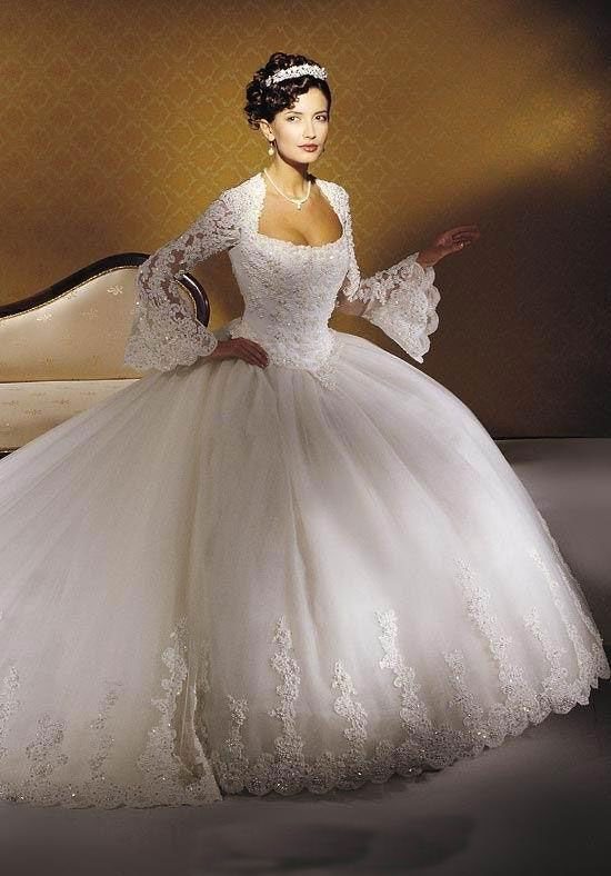 Woman in a white wedding gown with a voluminous full skirt and lace sleeves.