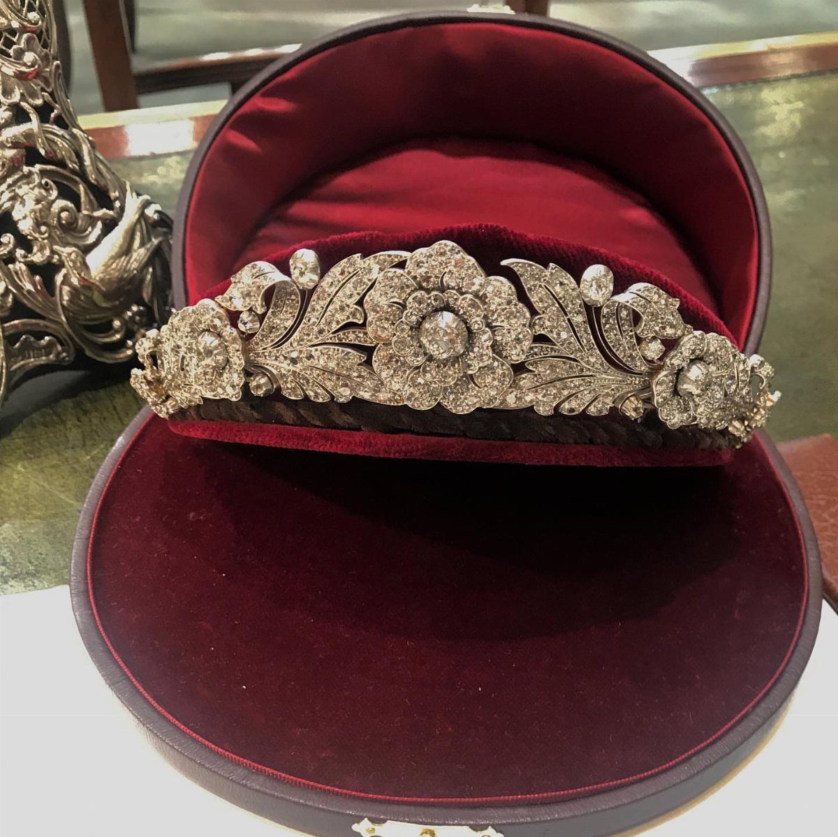 Silver floral tiara with crystals resting in a red velvet jewelry box