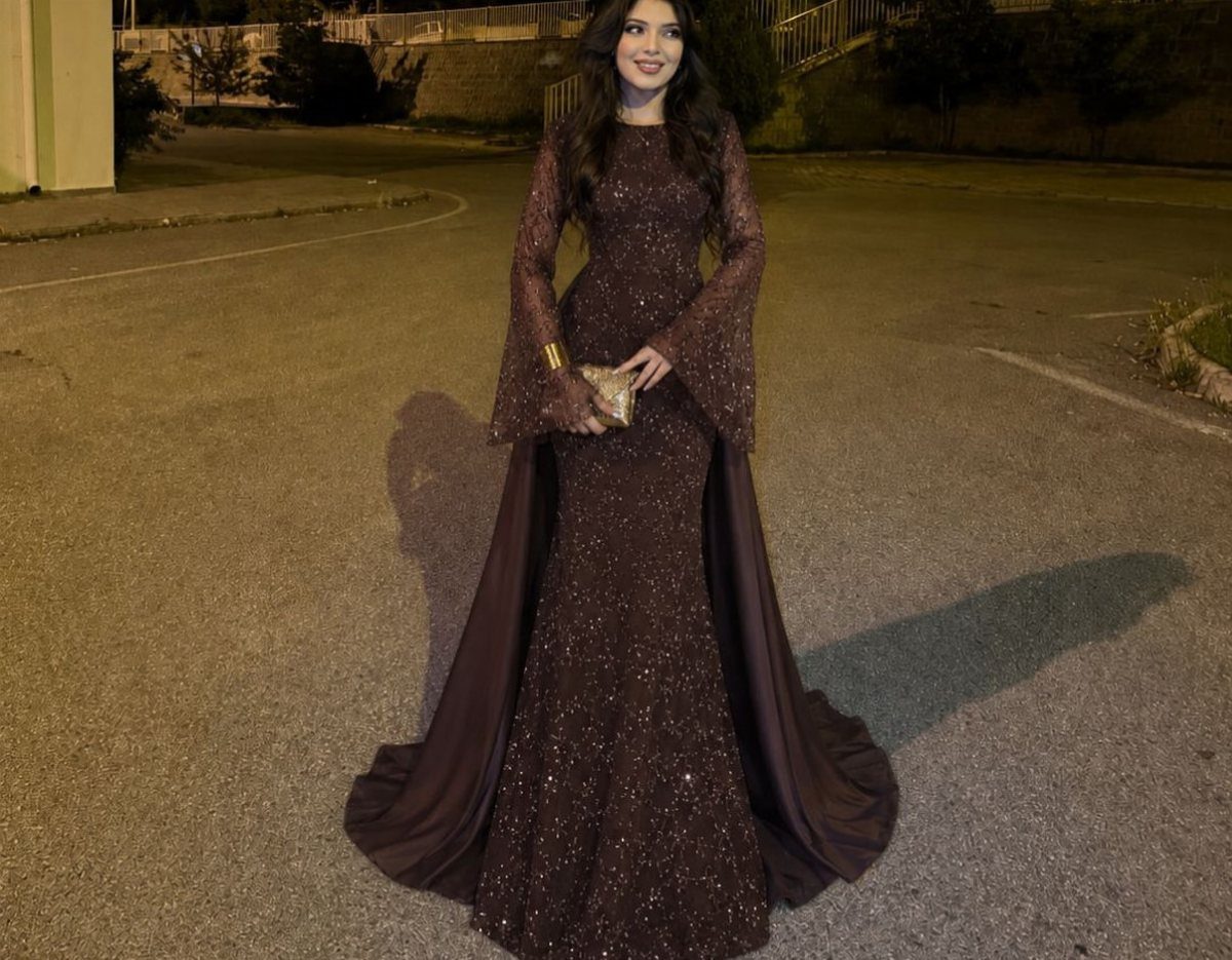 Woman in a sparkling dark brown mermaid gown with a flowing overskirt