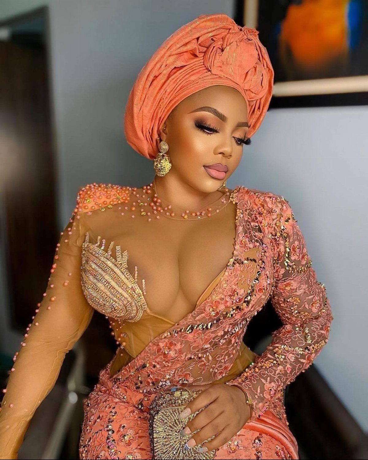 Woman in a peach Nigerian bridal dress with a matching gele headtie.