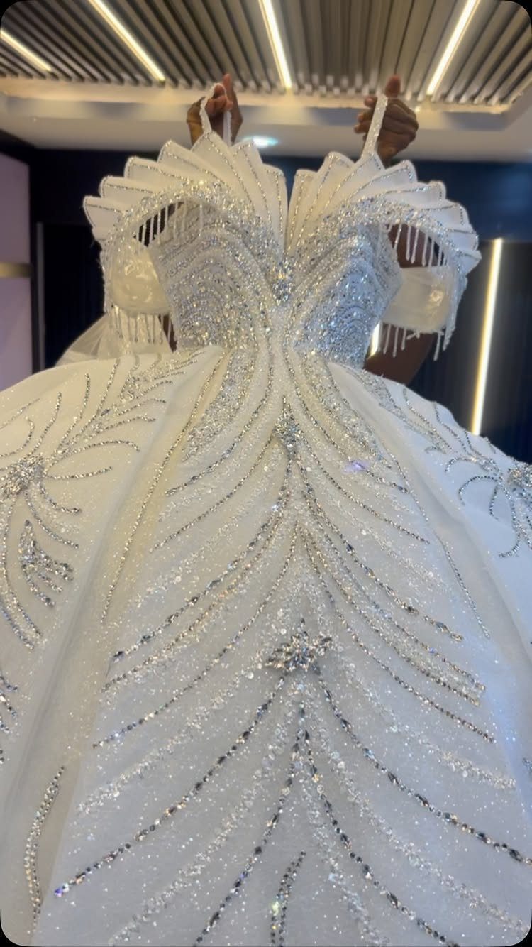 White ballroom wedding gown with silver sequins and a voluminous flared skirt.