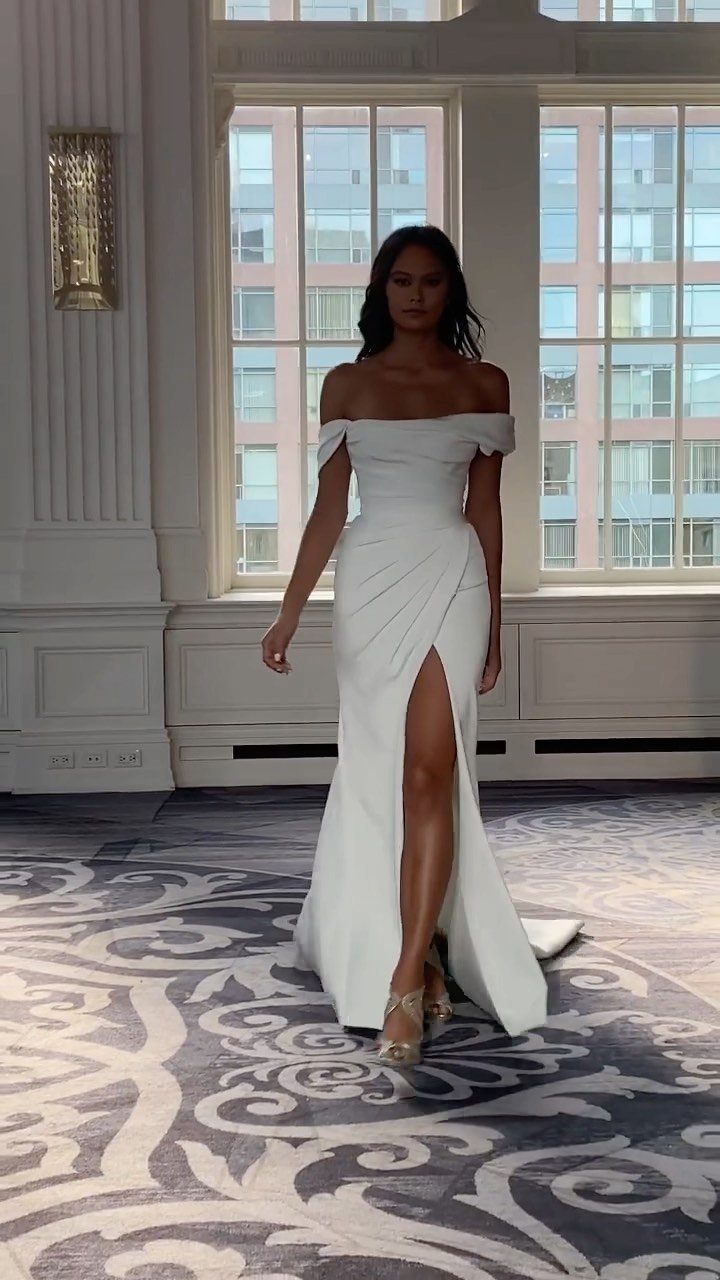 Woman in a white off-the-shoulder wedding gown with a high leg slit.