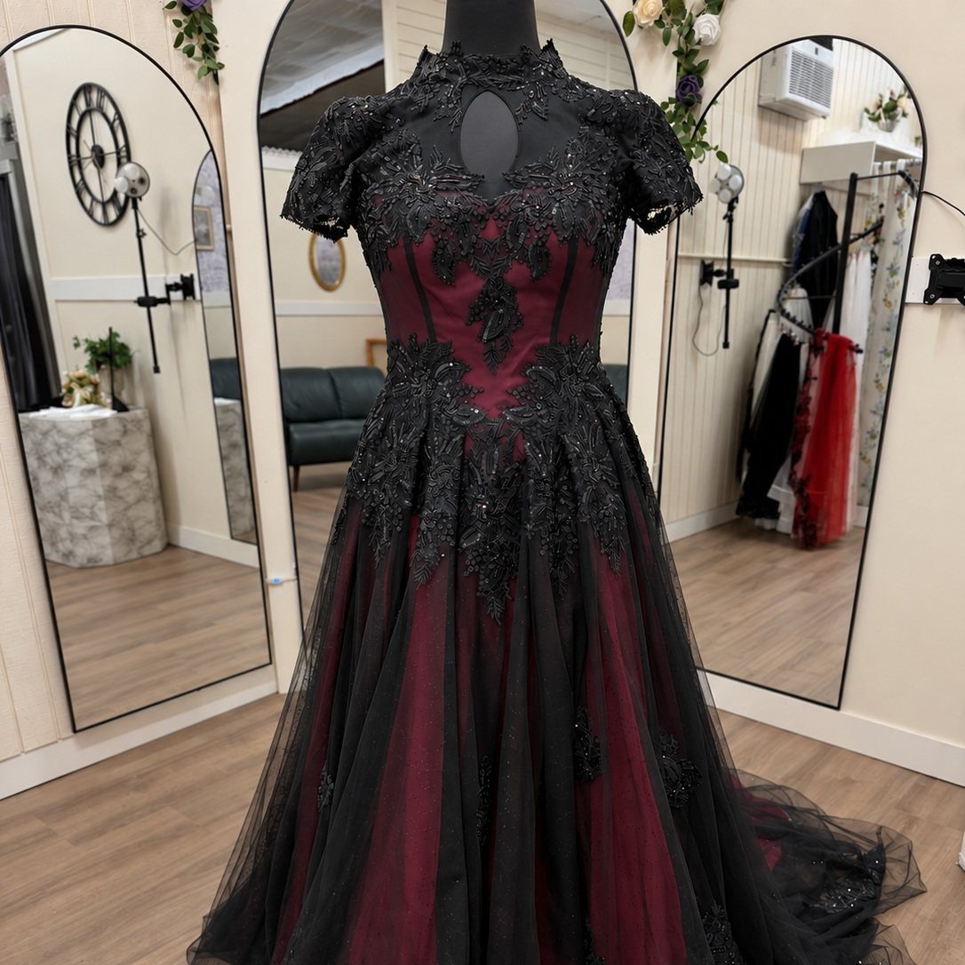Black and red gothic gown with intricate lace embroidery on a mannequin