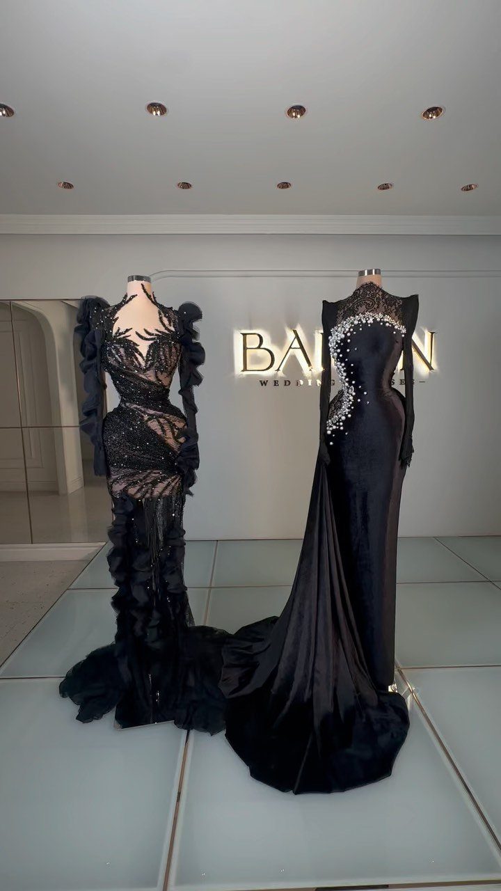 Two dramatic black wedding gowns on mannequins in a white minimalist studio.