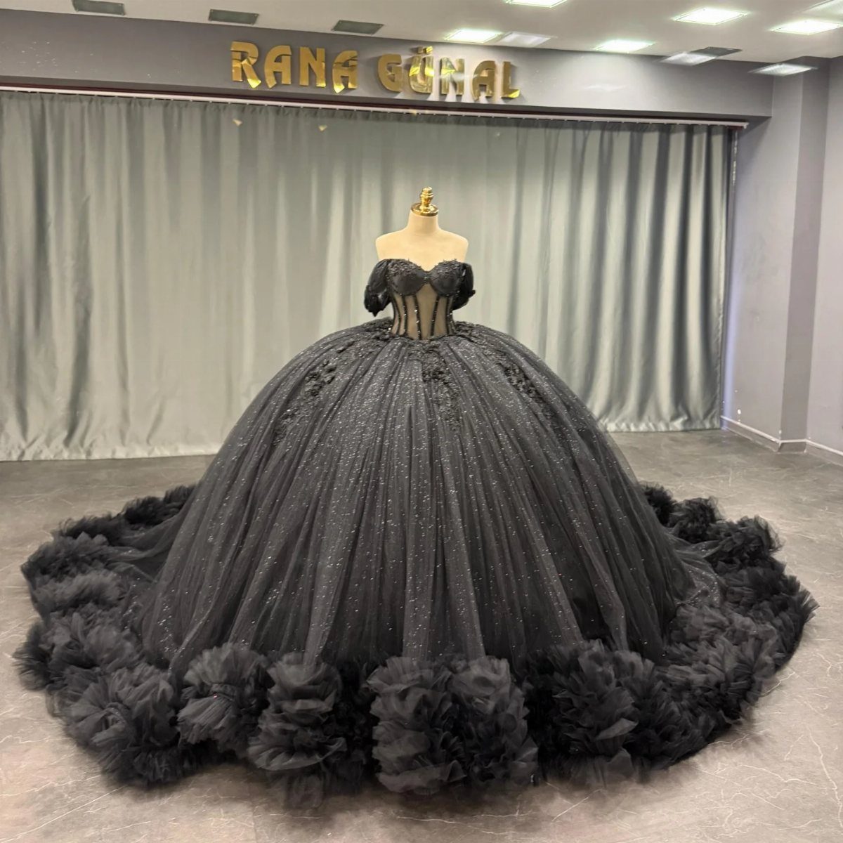 Black ballgown wedding dress with glittery tulle and ruffles on a mannequin.