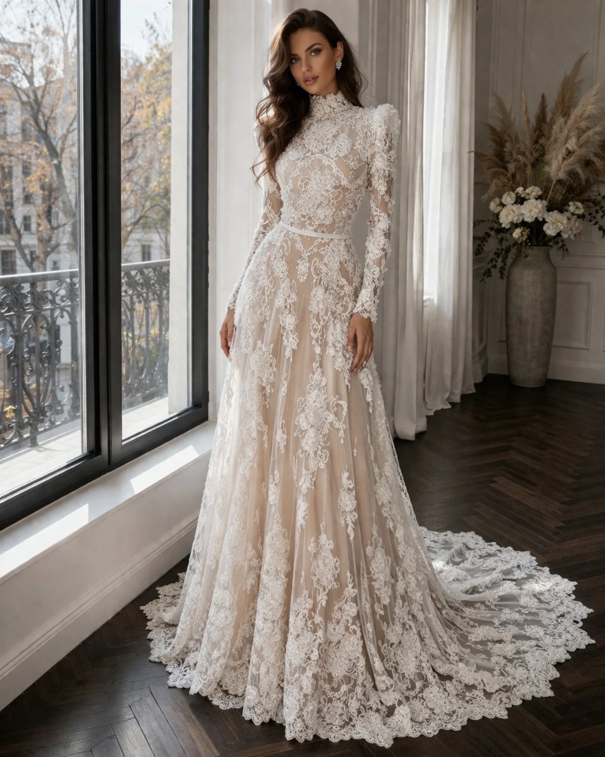 Woman in a long-sleeved lace boho bridal gown standing in a bright room.
