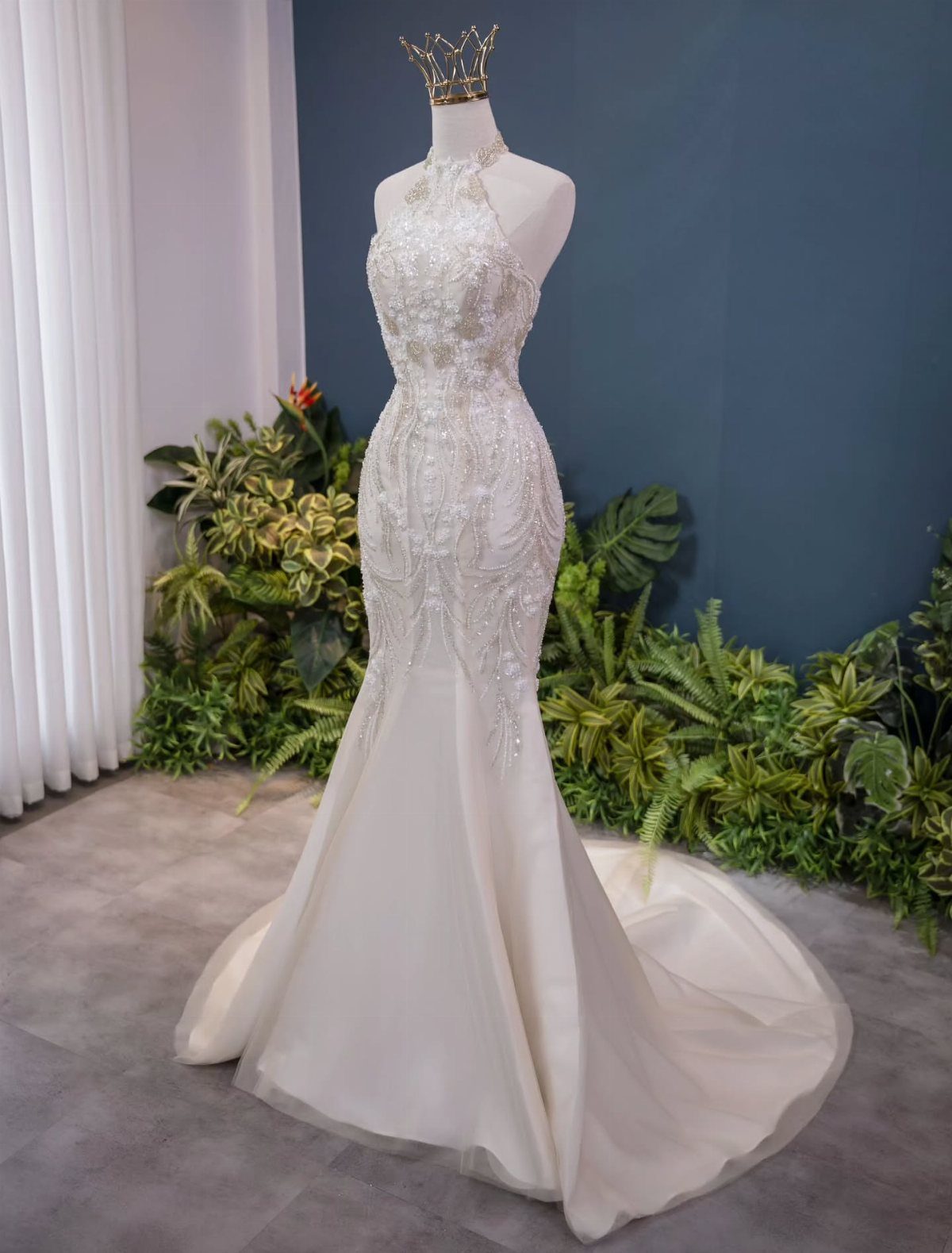 White mermaid bridal gown with halter neckline and lace on a mannequin.