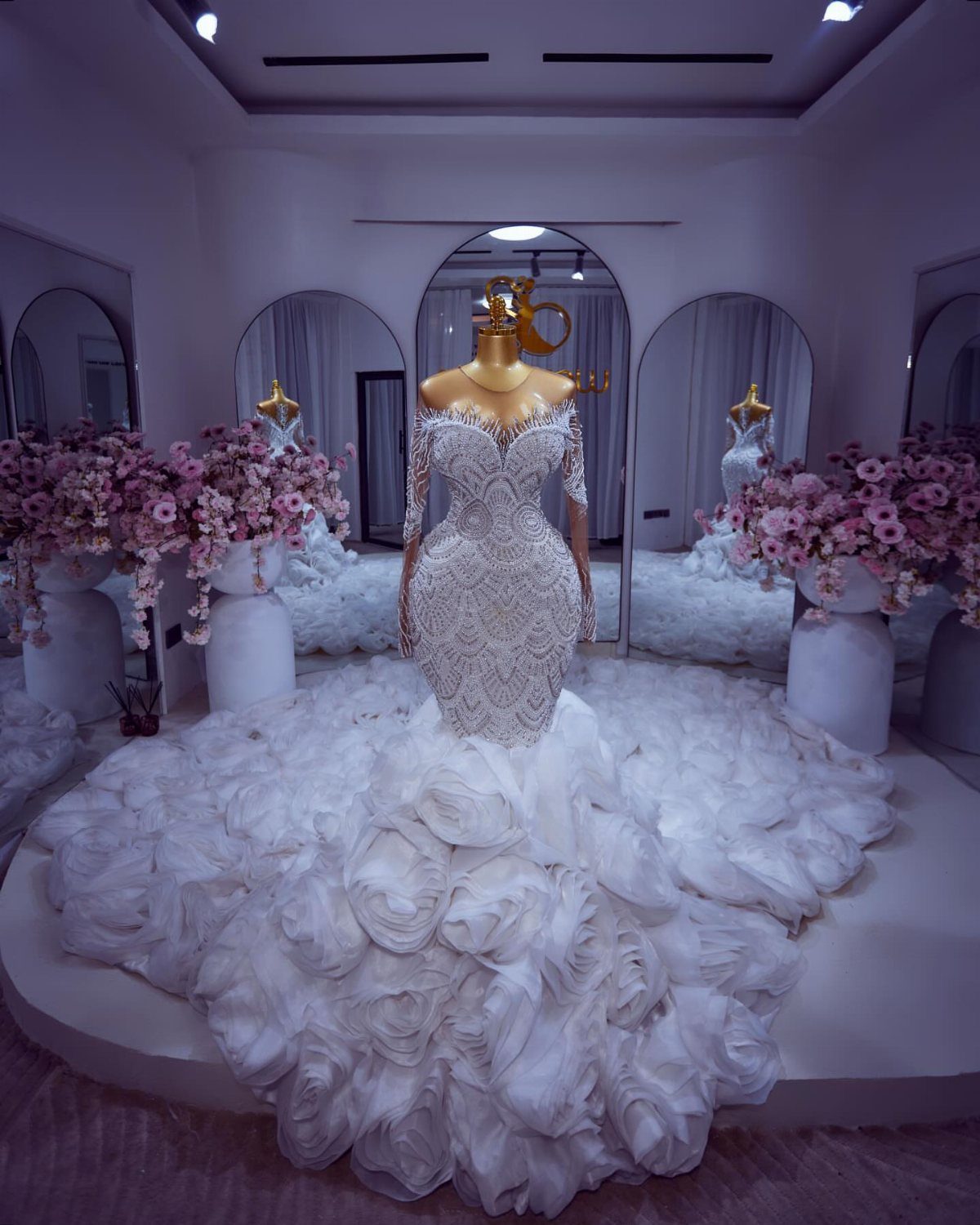 White mermaid bridal gown with beaded bodice and ruffled skirt on a mannequin