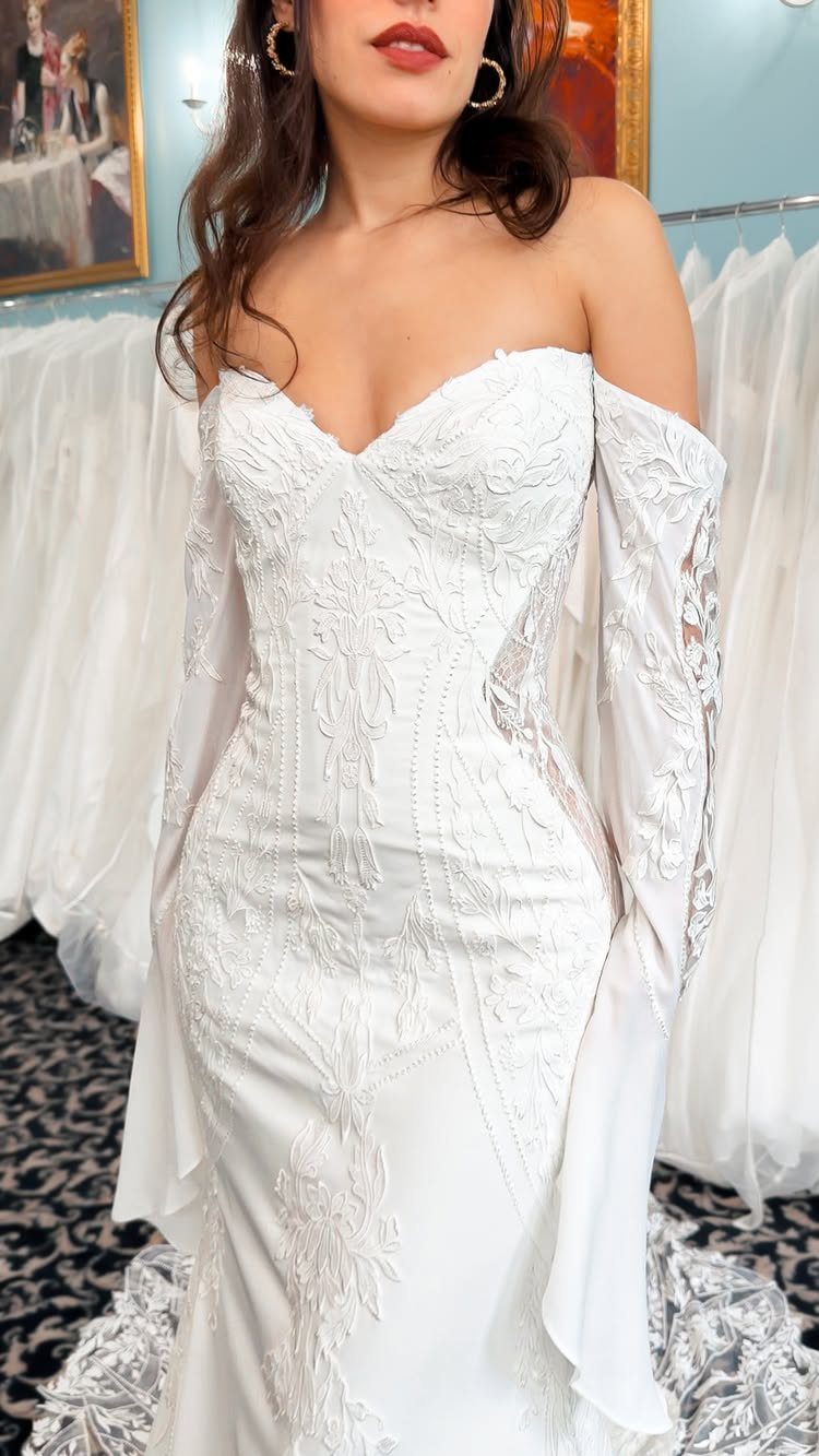 Woman in a white mermaid bridal gown featuring a sweetheart neckline and lace embroidery.