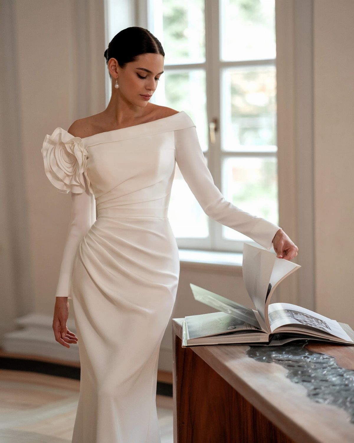 Woman in a white long-sleeved wedding dress with a statement floral shoulder neckline.