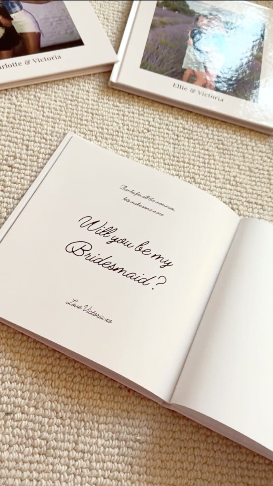 Open white photo album asking Will you be my Bridesmaid on a beige surface