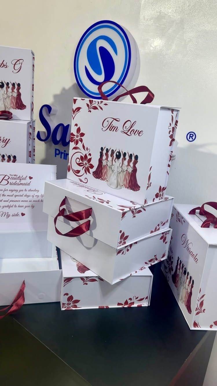 White personalized gift bags with red floral designs and bridesmaid illustrations.