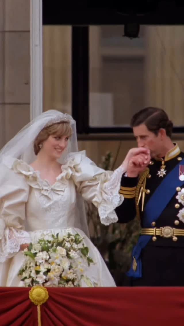 Princess Diana in her ivory silk taffeta wedding gown standing with Prince Charles.