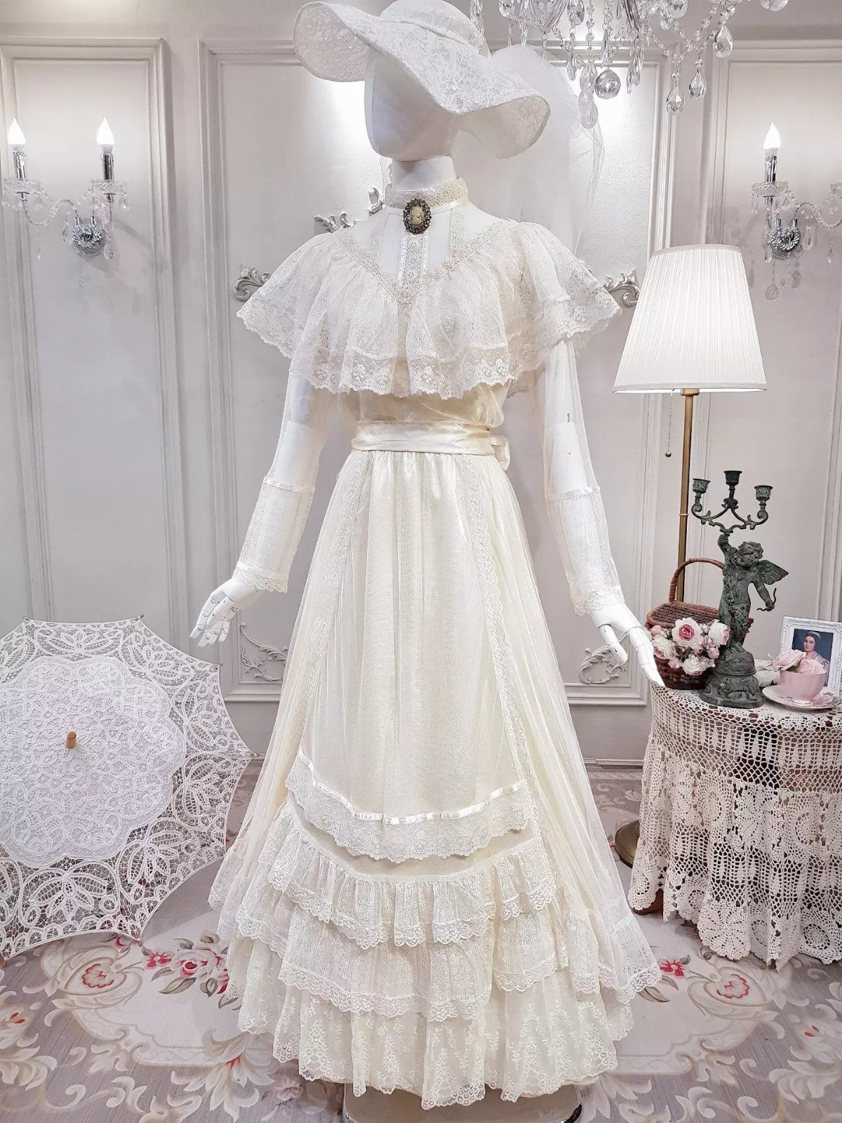 Vintage white lace bridal dress with tiered ruffles and matching wide-brimmed hat