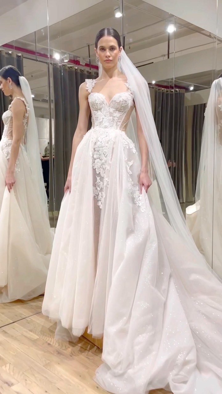 Woman in a white lace bridal gown and long veil in a salon