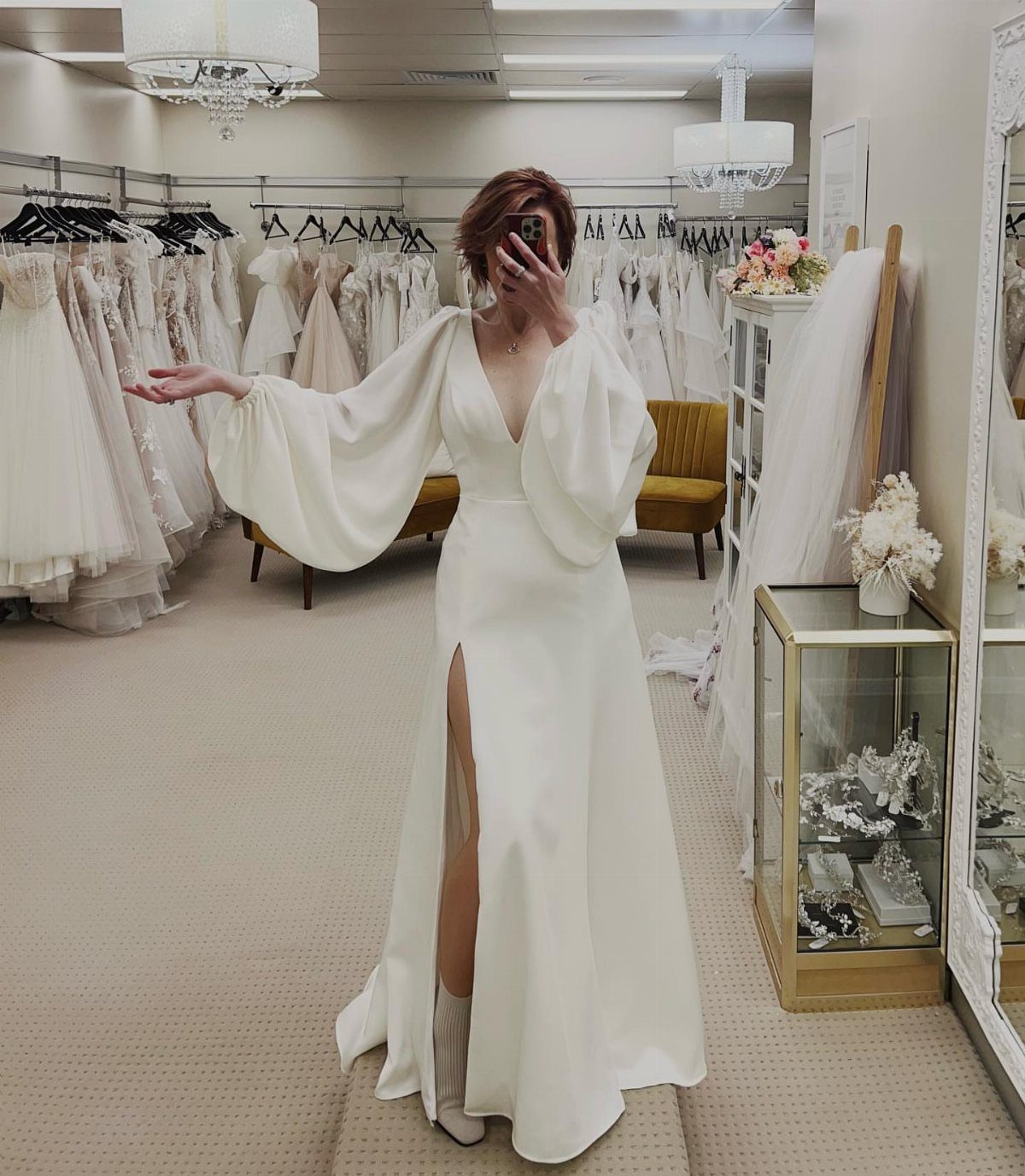 Woman in a white bridal gown with puff sleeves and a high leg slit