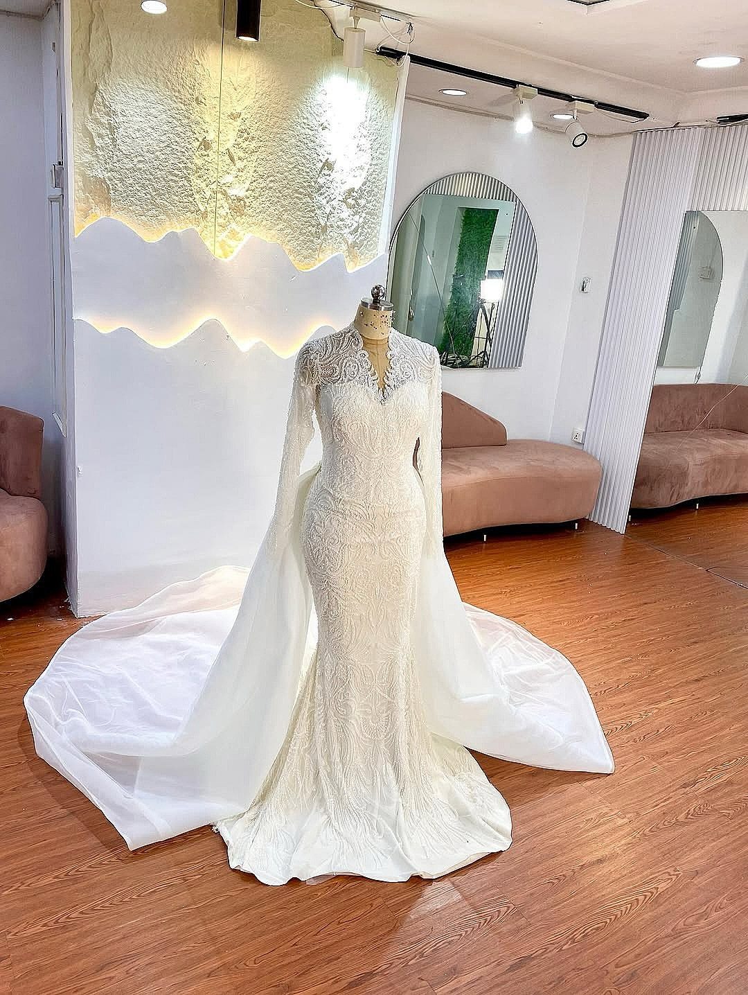 Beaded white wedding dress with long train on a mannequin in a boutique