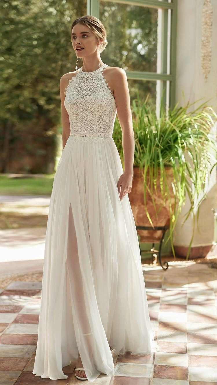 Woman in a white lace halter wedding dress with a flowing slit skirt.
