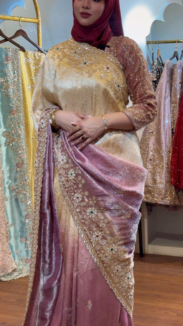 Woman wearing a gold and purple embroidered designer saree with a maroon hijab.