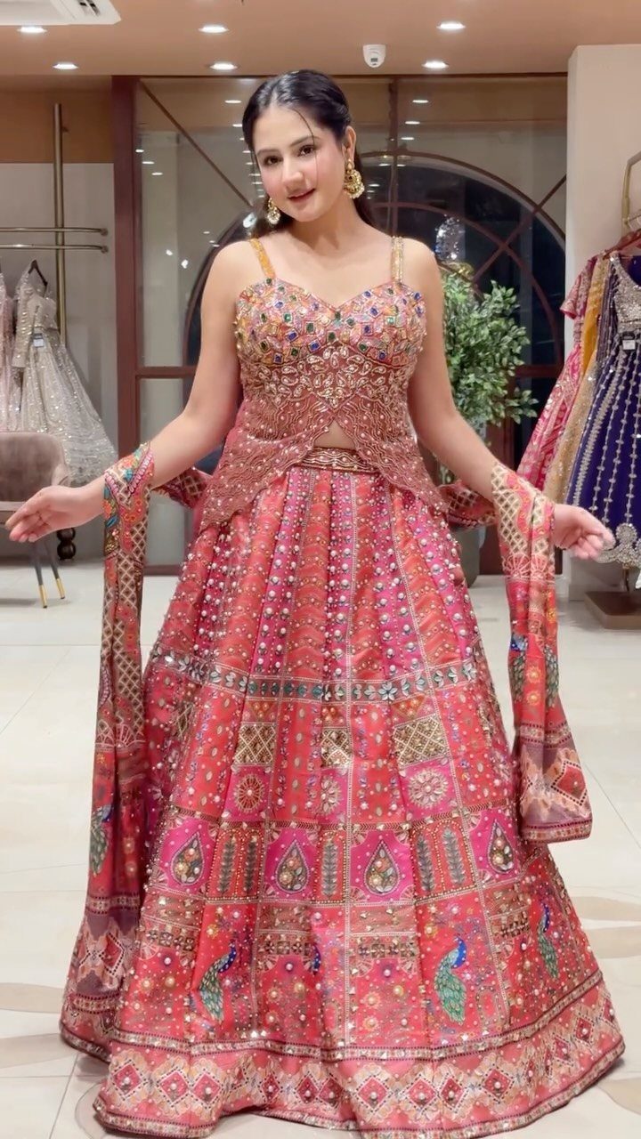 Woman wearing a red and gold embroidered lehenga choli in a boutique