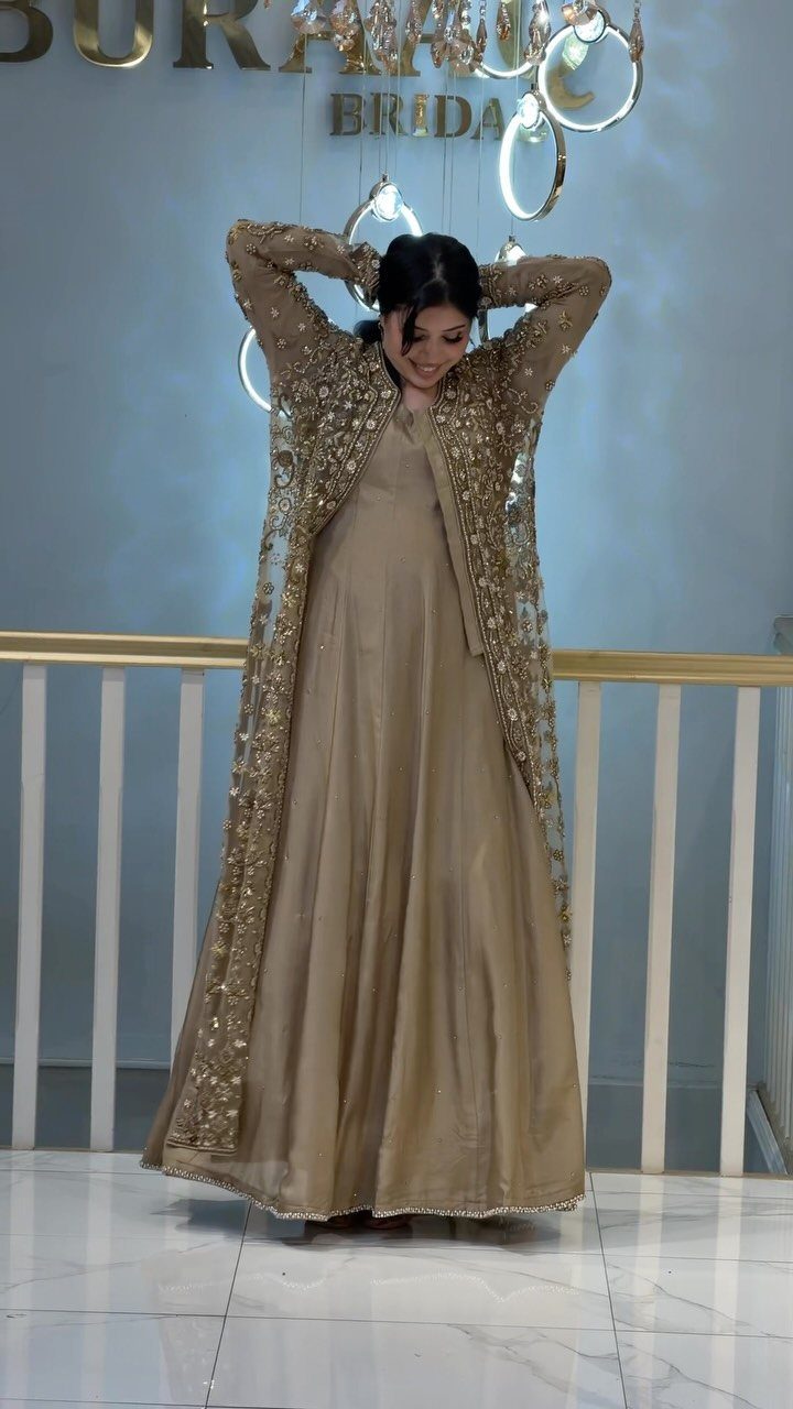 Woman in a gold jacquard wedding dress with an embroidered long jacket.