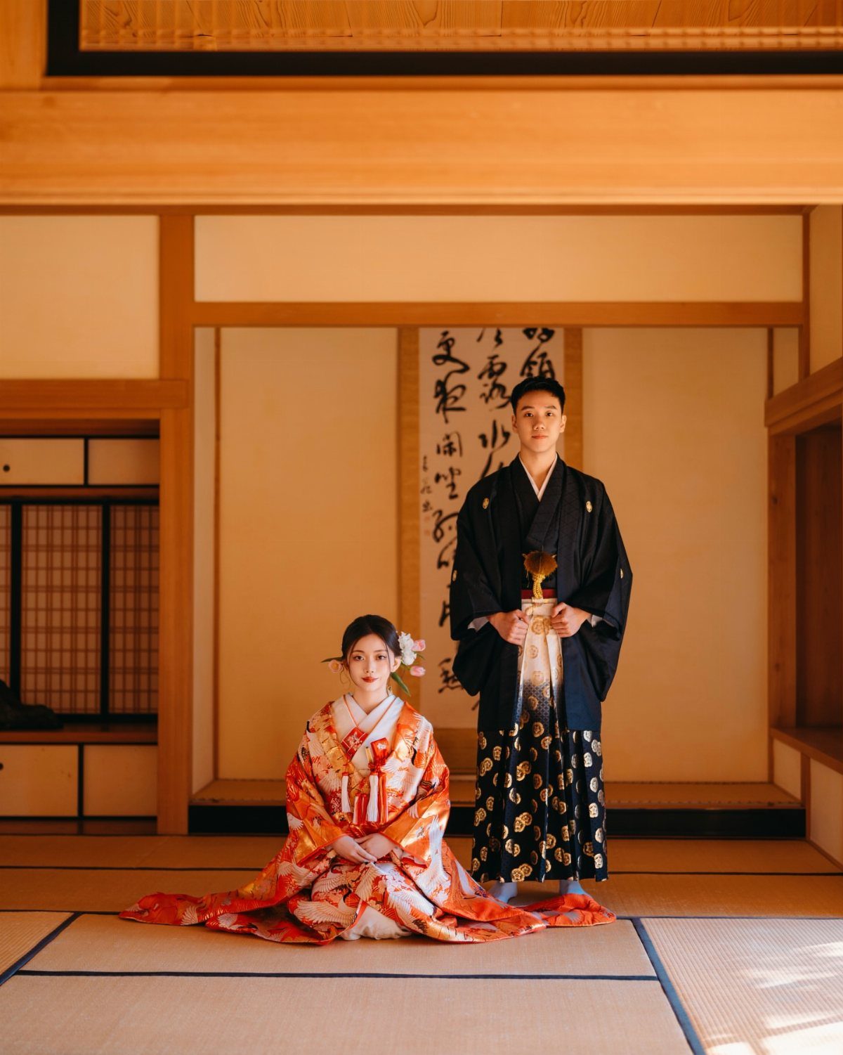 Japanese couple in traditional wedding attire, woman in red embroidered Iro-Uchikake kimono.