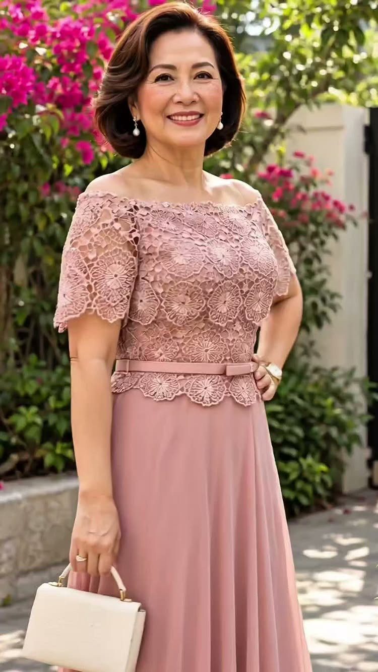 Woman in a dusty rose lace formal gown holding a white clutch outdoors.