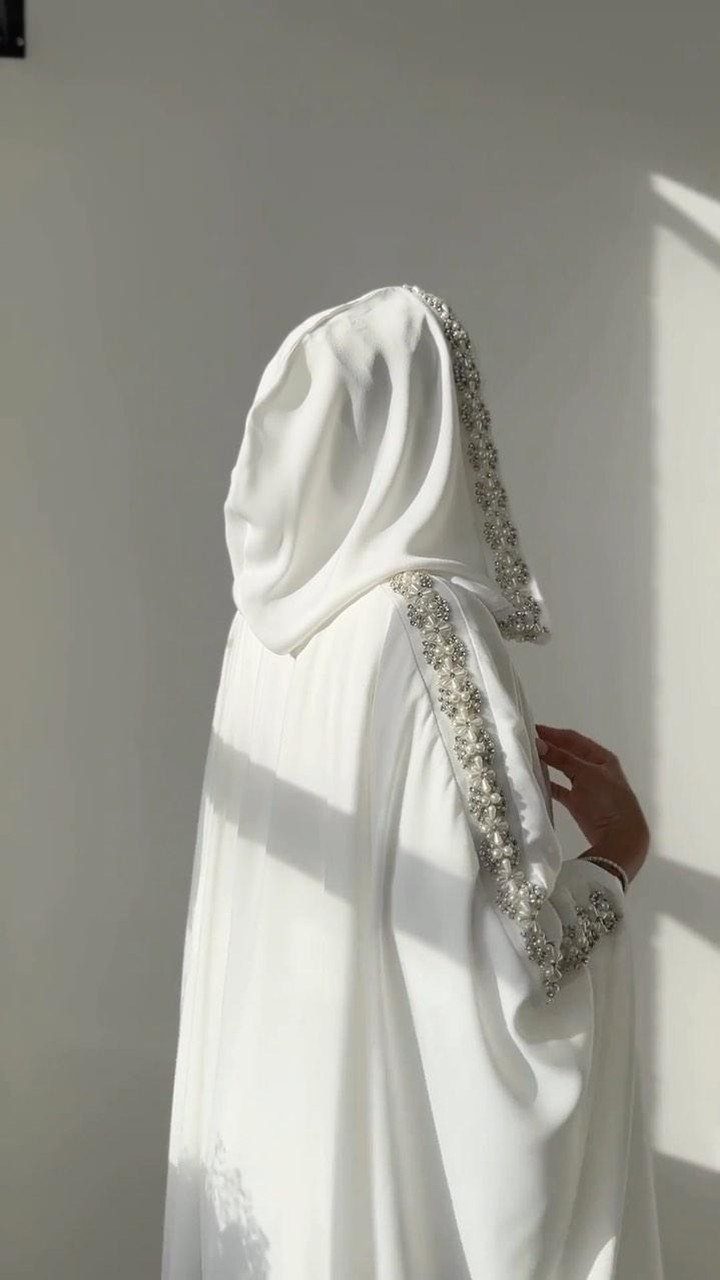 White wedding gown with a matching hooded cape and silver embroidered edges.