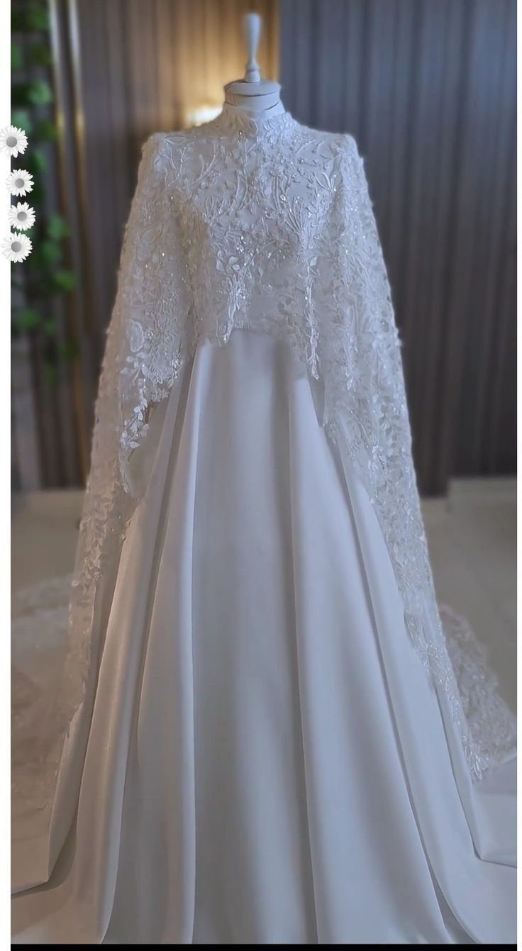 White modest wedding dress with lace capelet and A-line satin skirt on mannequin