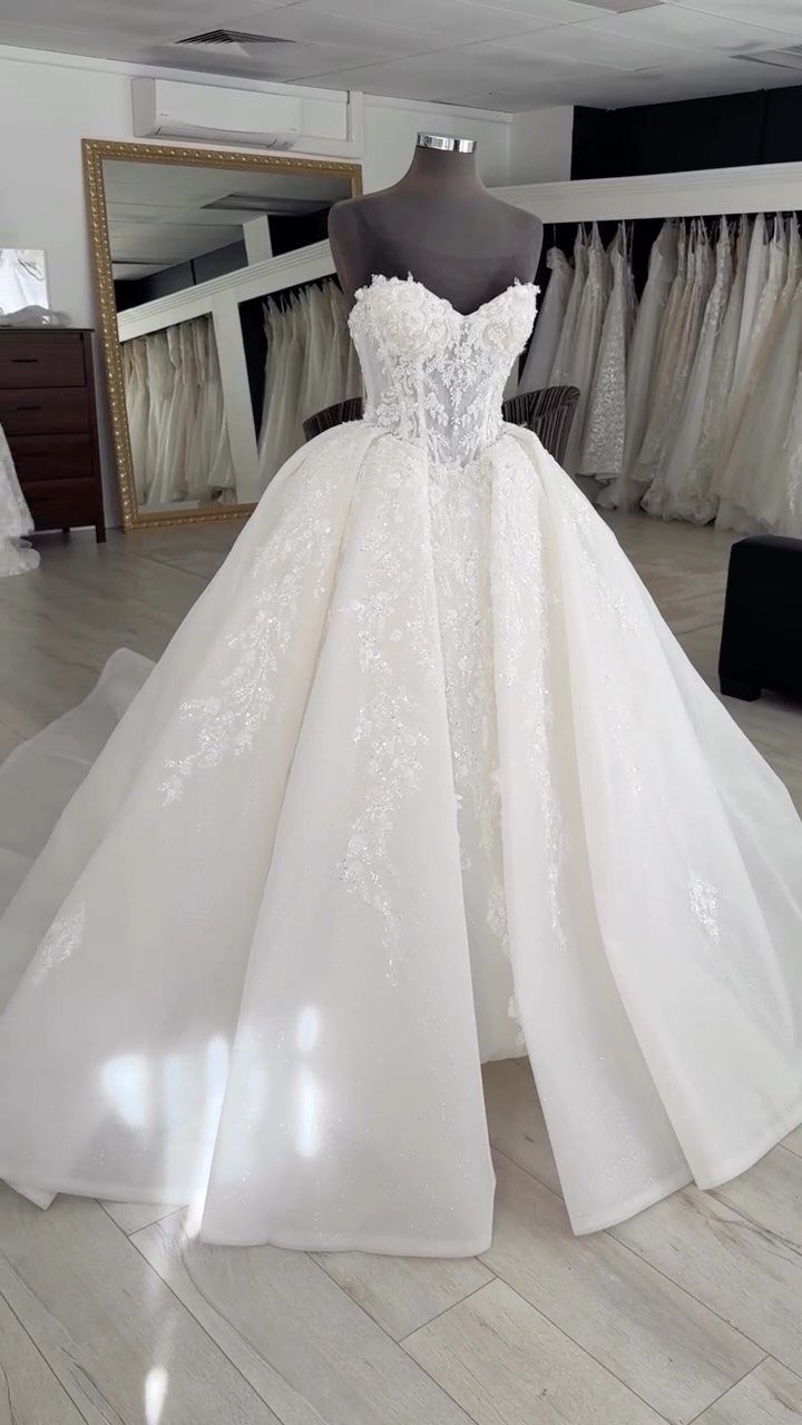 White princess wedding gown on a mannequin with a fitted lace bodice and voluminous skirt