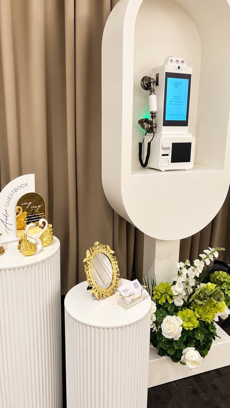 Digital video guest book station with vintage phone handset and white floral decor