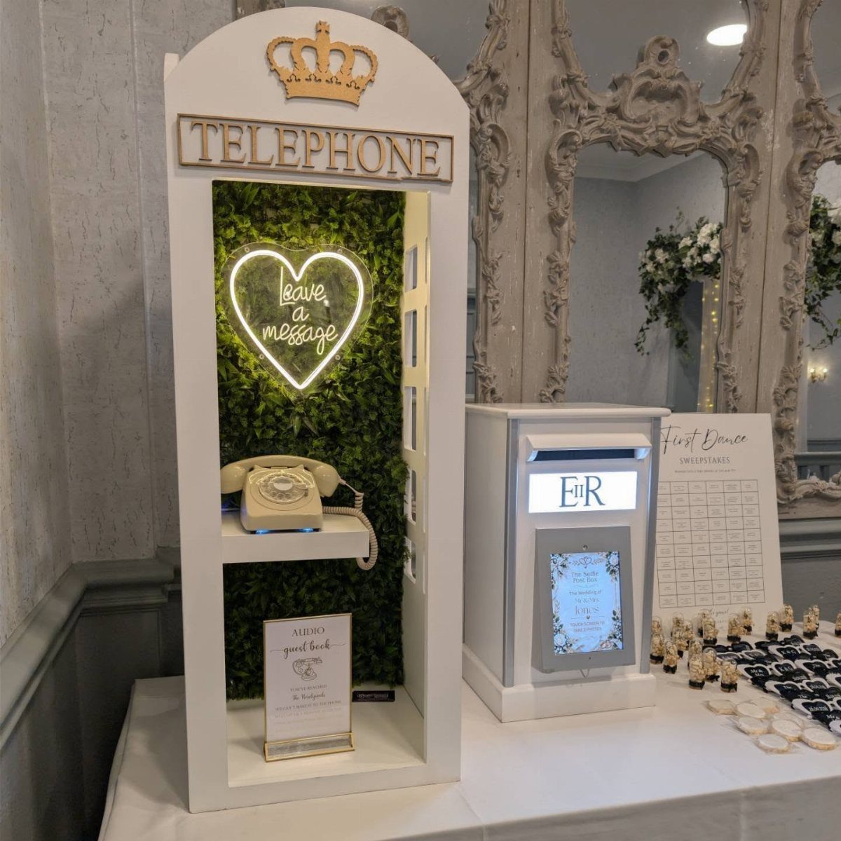 Vintage cream rotary phone inside a white booth with a neon heart sign.