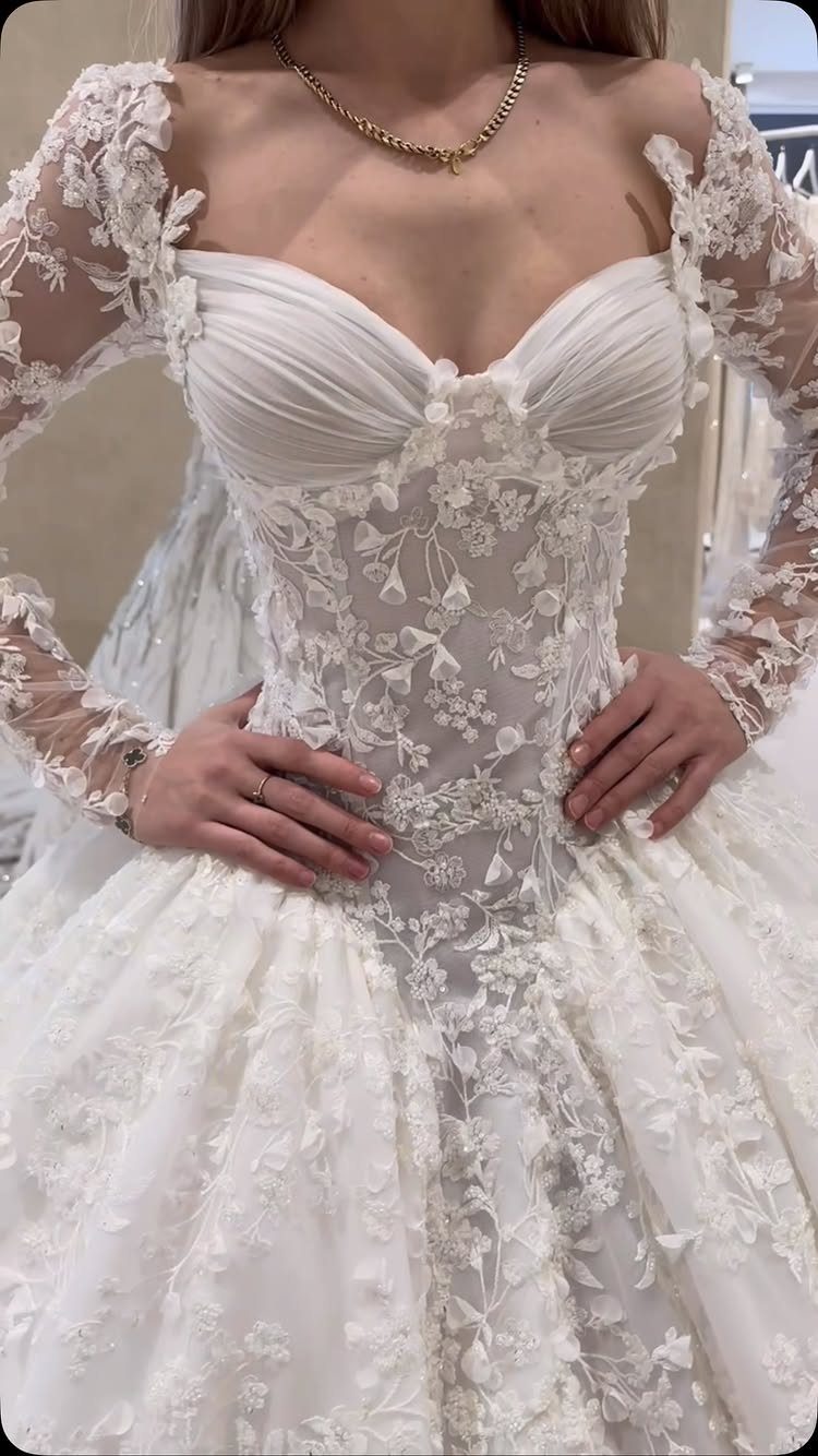 White lace ball gown wedding dress with long sleeves and floral embroidery