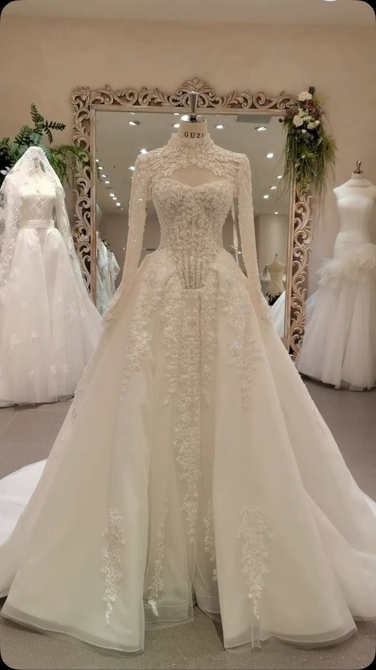 White lace wedding dress with long sleeves and full skirt on a mannequin
