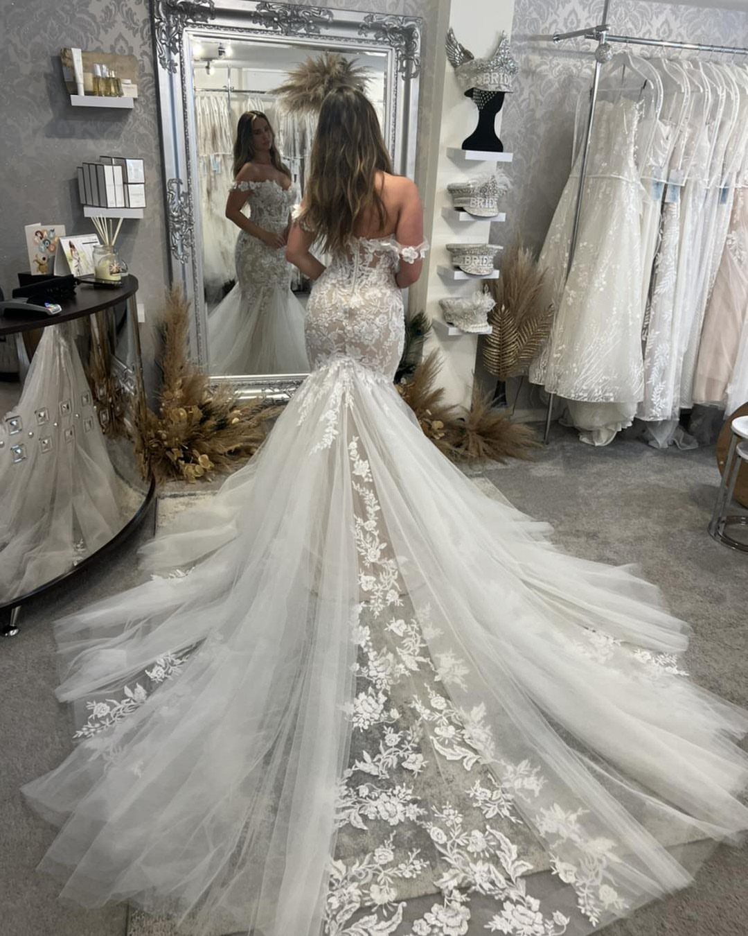 Woman wearing a white lace wedding gown with a long dramatic tulle train