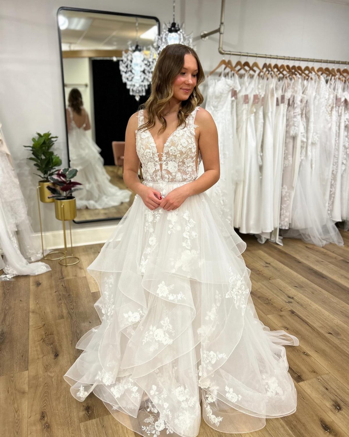 Woman wearing a white wedding dress with a cascading ruffle skirt and lace bodice