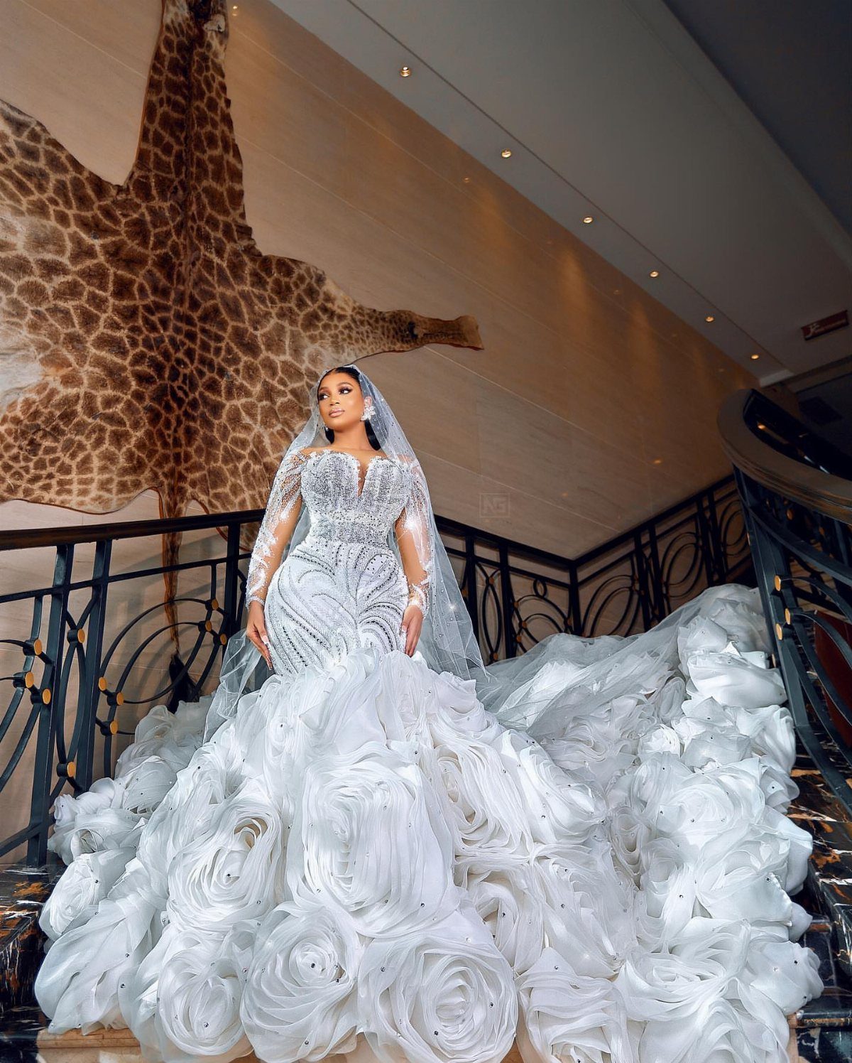 Woman in a white wedding dress with a massive rosette ruffle skirt on stairs