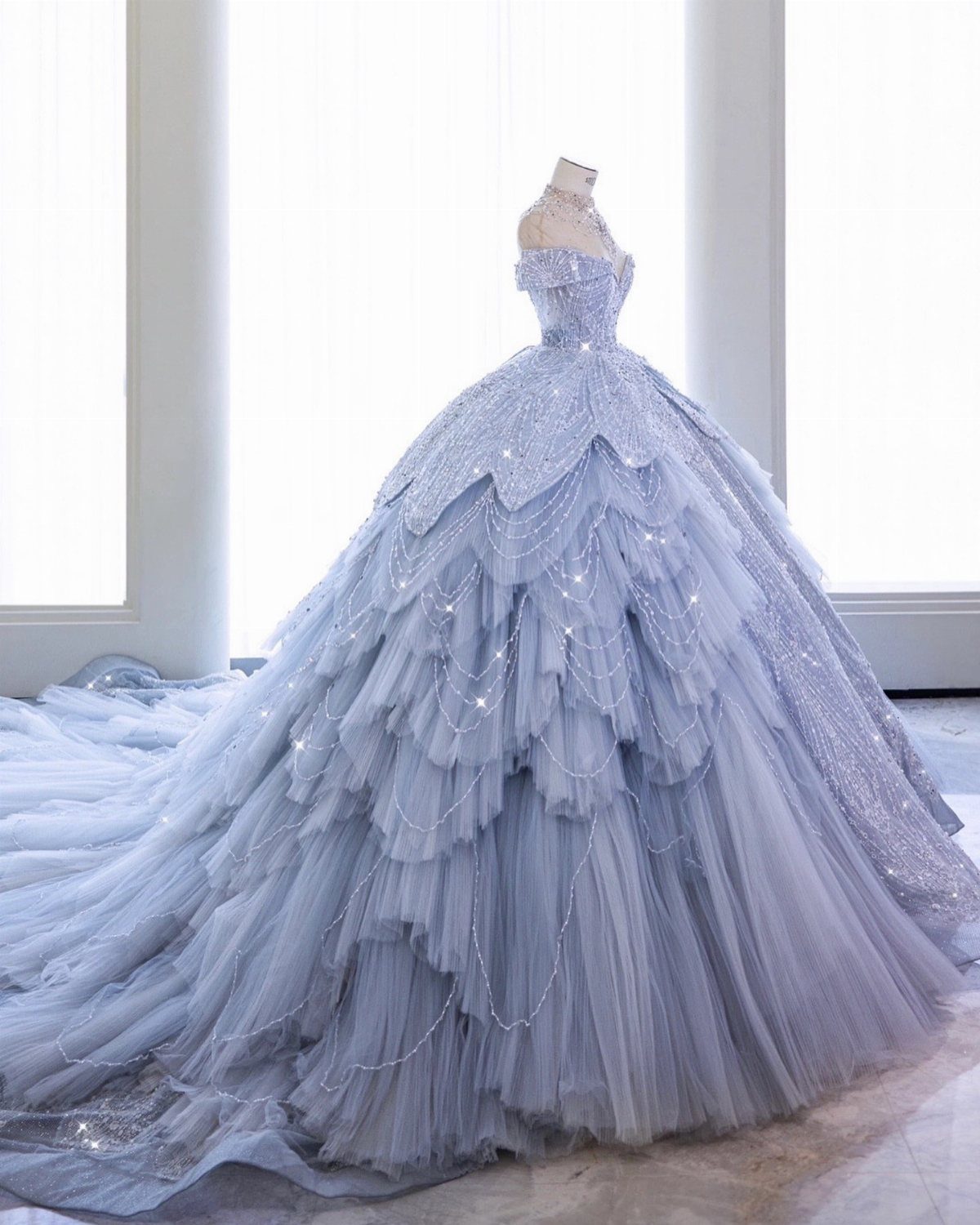 Light blue ball gown wedding dress with cascading tulle ruffles on a mannequin