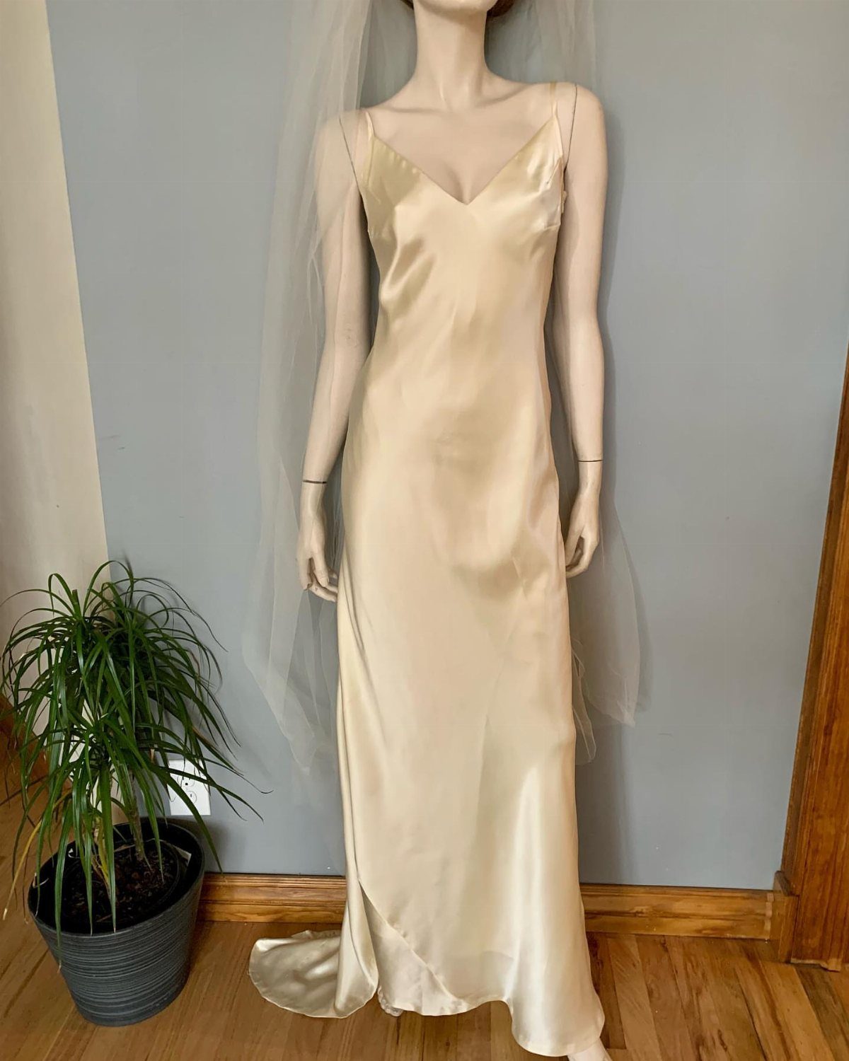 Champagne satin slip wedding dress on a mannequin with a sheer white veil.