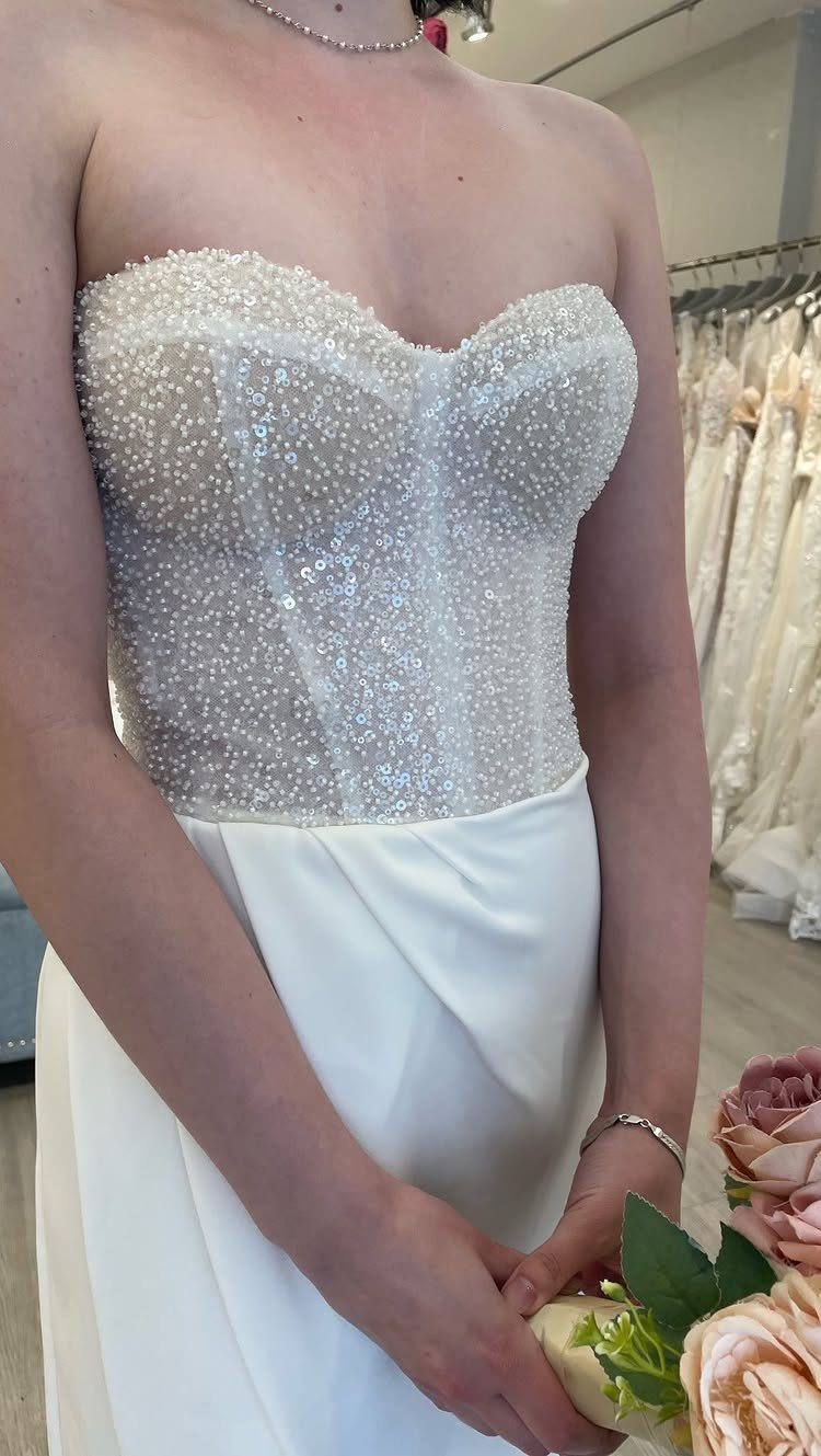 Strapless wedding dress with a sweetheart neckline and pearl-embellished bodice.