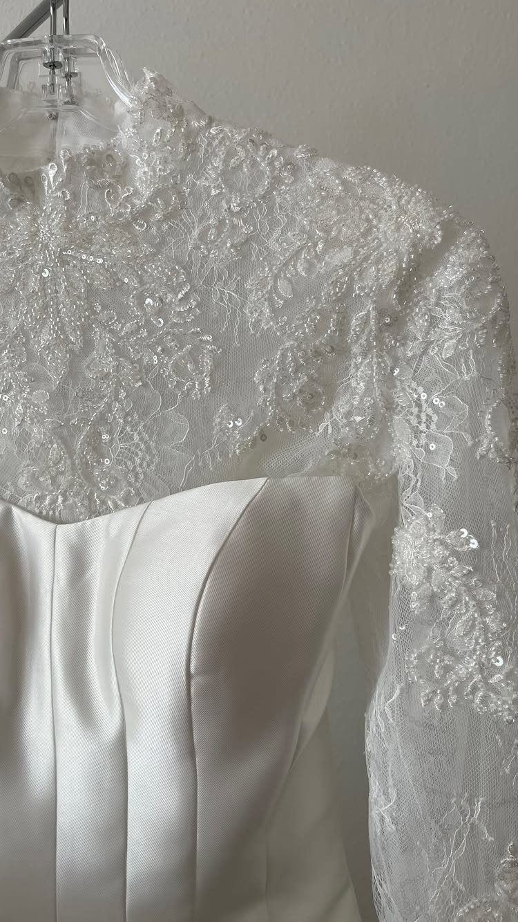 White lace sequined bolero worn over a white satin strapless wedding dress