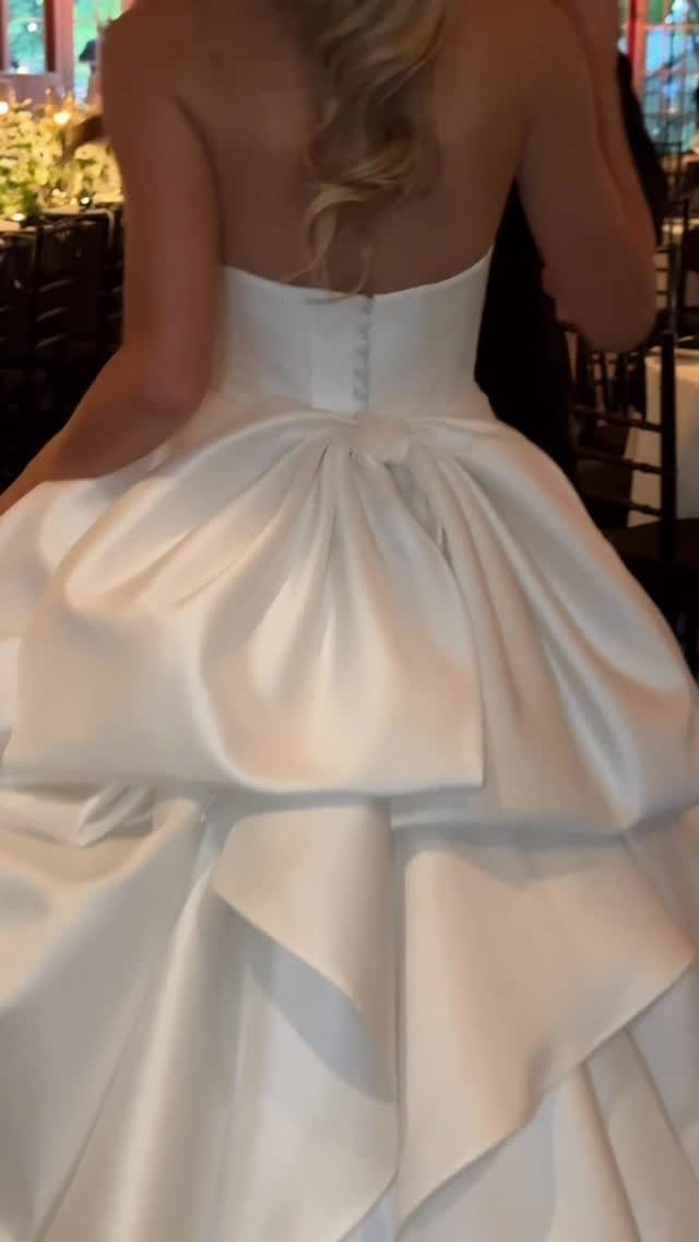 White satin wedding dress with a large statement bow bustle on the back
