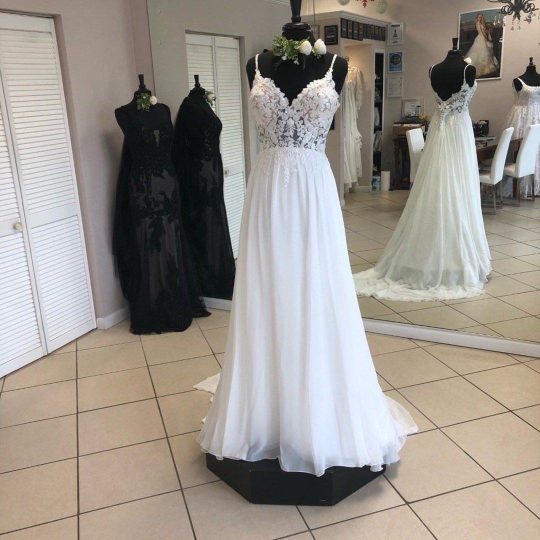 White wedding dress with lace bodice and chiffon skirt on a mannequin