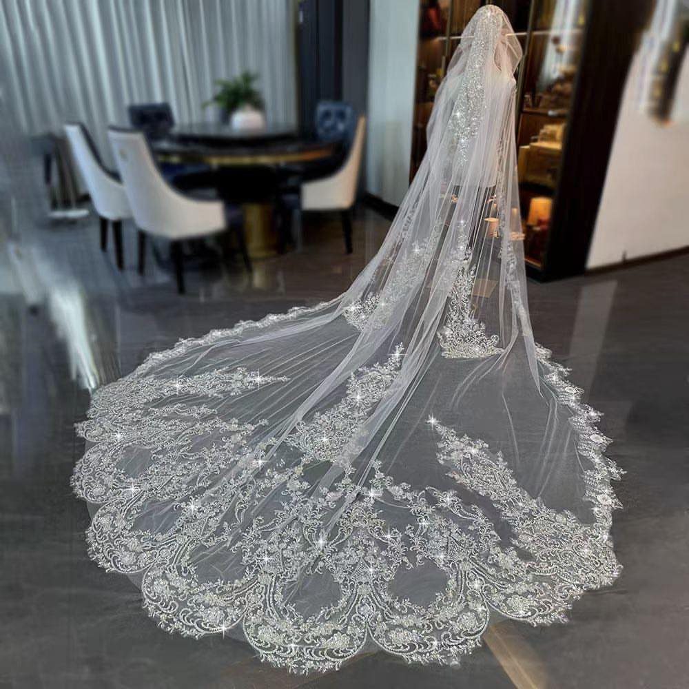 Long white bridal veil with silver lace embroidery and sequins on a mannequin.