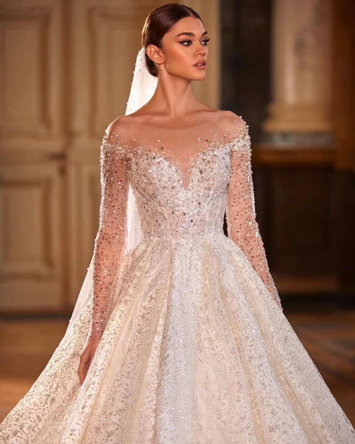 Woman in a beaded illusion flowy wedding gown with a full shimmering skirt