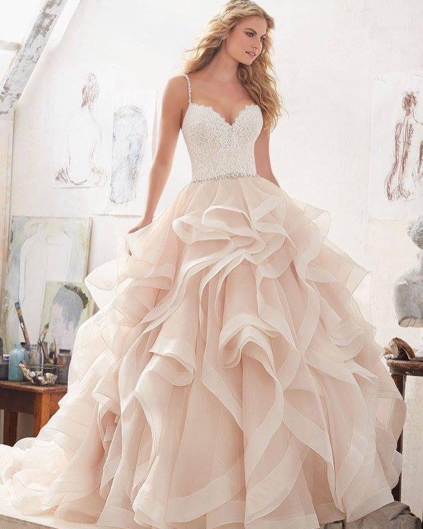 Woman in a champagne wedding dress with a ruffled skirt in an art studio