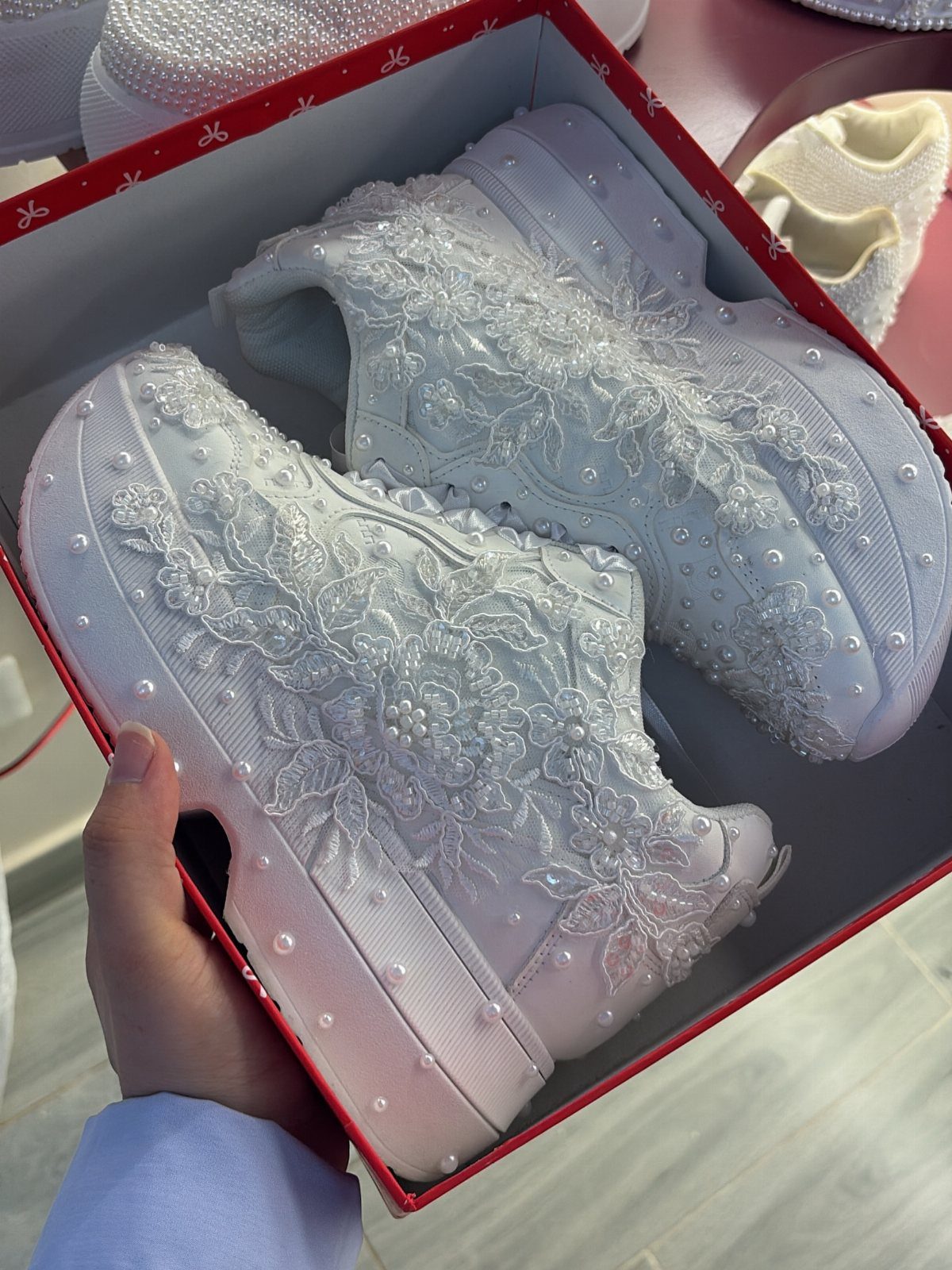 White platform sneakers with lace and pearl embroidery in a red box