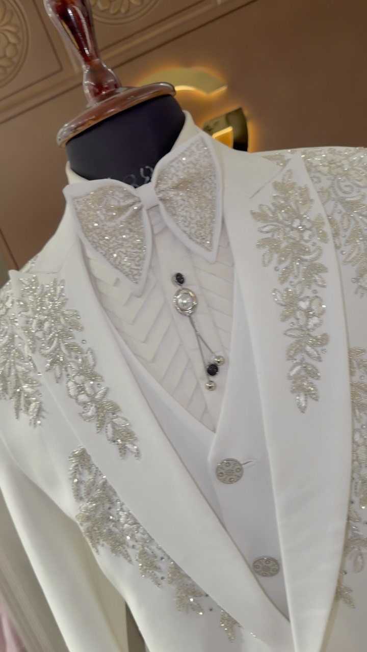 White formal wedding suit with silver beaded embroidery on a mannequin