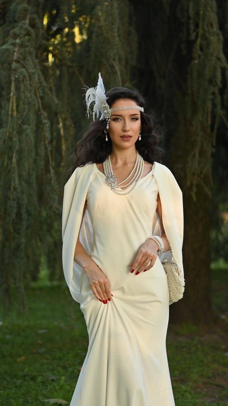 Woman in a cream 1920s vintage style wedding dress with pearls and headband.